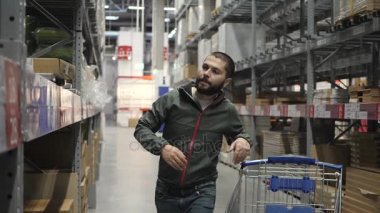 Yakışıklı adam alışveriş bir süpermarket veya Ambar