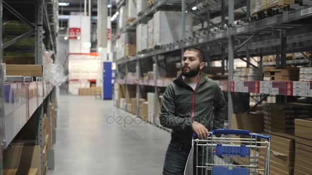 Handsome man shopping in a supermarket or warehouse — Stock Video