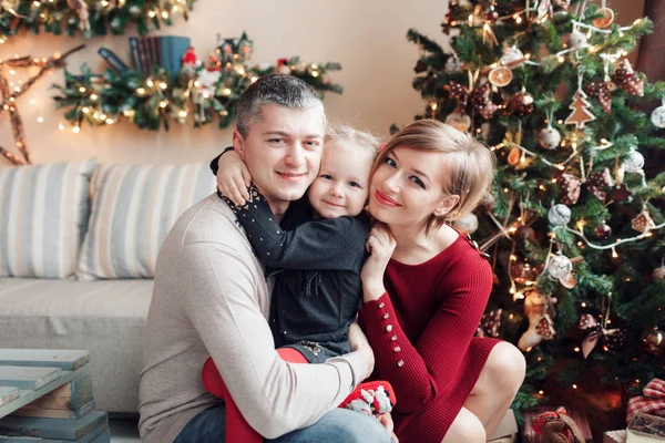 Noel sabahı kameraya bakarak genç dostu aile portresi. Baba, anne ve kızı — Stok fotoğraf