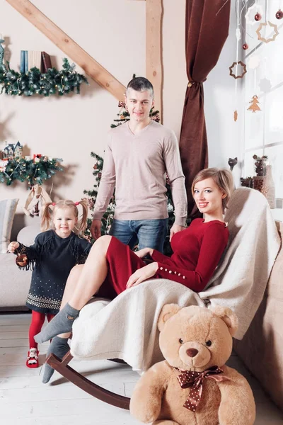 Noel sabahı kameraya bakarak genç dostu aile portresi. Baba, anne ve kızı — Stok fotoğraf