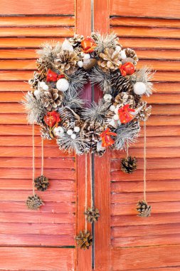 Ahşap jaluzi üzerinde asılı Noel çelenk