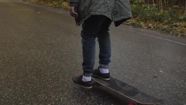 Bir orman yoluyla bir yolda bir longboard skate haritasında kişini — Stok video
