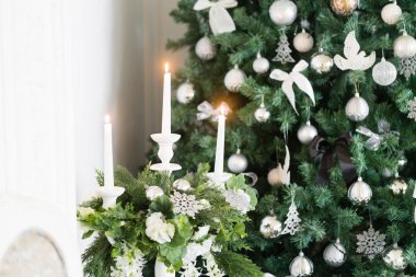 Noel sabahı. Beyaz şömineli klasik daireler, dekore edilmiş ağaç, parlak kanepe, büyük pencereler.