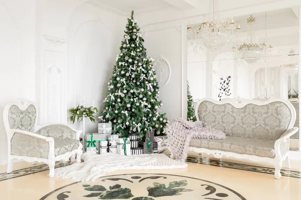 Mañana de Navidad. apartamentos clásicos con chimenea blanca, árbol decorado, sofá luminoso, grandes ventanales — Foto de Stock