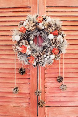 Ahşap jaluzi üzerinde asılı Noel çelenk
