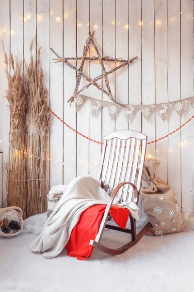 Mañana de Navidad. Silla mecedora con decoración de leña y pared de madera —  Fotos de Stock