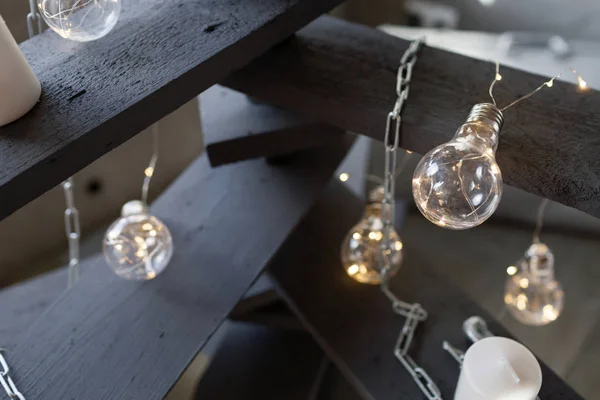 Alternative wooden christmas tree. A handmade Christmas tree and light bulb on the floor in the room — Stock Photo, Image
