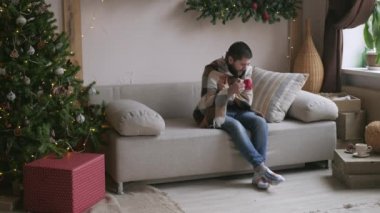 Güzel genç çift evde kutluyor. Güzel kız erkek arkadaşı bir hediye kutusu veriyor