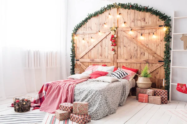 Navidad en el dormitorio de la mañana. Cama doble en Navidad Interior sobre fondo de pared de madera — Foto de Stock