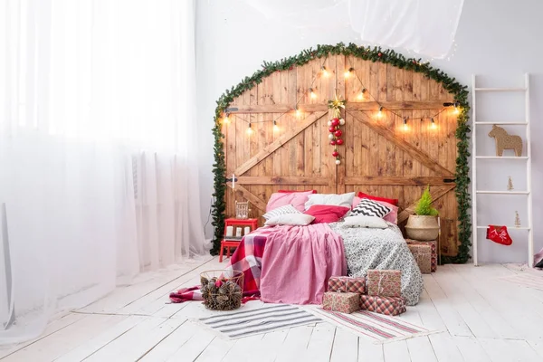 Navidad en el dormitorio de la mañana. Cama doble en Navidad Interior sobre fondo de pared de madera —  Fotos de Stock