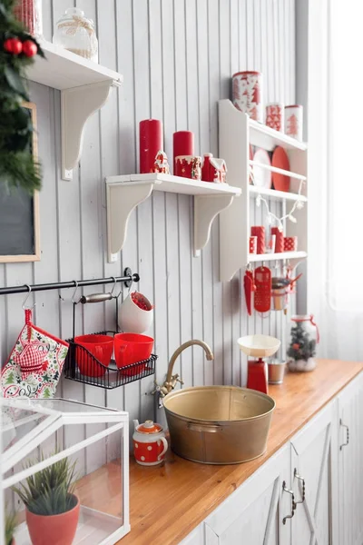 Ράφια με πιάτα. Εσωτερική ελαφριά κουζίνα γκρίζα και κόκκινη διακόσμηση για τα Χριστούγεννα. Προετοιμασία του γεύματος στο σπίτι, σχετικά με την έννοια της κουζίνας. — Φωτογραφία Αρχείου