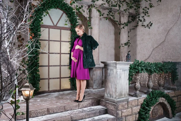 Bonito grávida mãe fica no belo terraço decorado Natal, tempo de gravidez feliz — Fotografia de Stock