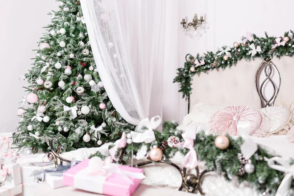 Acogedor interior de casa de Navidad. Concéntrate en el árbol. Decoración de año nuevo. luminoso dormitorio con cama doble grande . — Foto de Stock