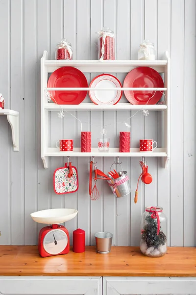 Schappen met gerechten. Interieur licht grijze keuken en rode kerst decor. Voorbereiding van de lunch thuis op het concept van de keuken. — Stockfoto