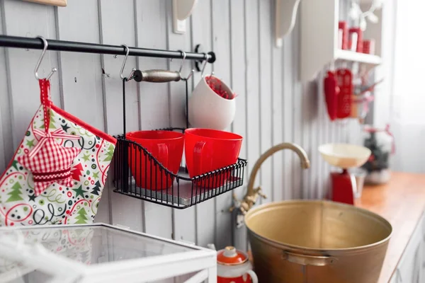 Ράφια με πιάτα. Εσωτερική ελαφριά κουζίνα γκρίζα και κόκκινη διακόσμηση για τα Χριστούγεννα. Προετοιμασία του γεύματος στο σπίτι, σχετικά με την έννοια της κουζίνας. — Φωτογραφία Αρχείου