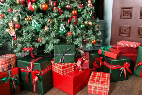 Noel hediyeler yakın çekim Noel ağacının altında yığını. Kırmızı ve yeşil sunar — Stok fotoğraf