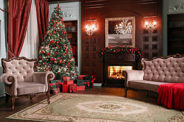 Weihnachtsabend. klassische Appartements mit weißem Kamin, geschmücktem Baum, Sofa, großen Fenstern und Kronleuchter. — Stockfoto