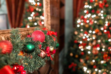 Dekore edilmiş bir Noel daldan asılı kırmızı ve yeşil önemsiz şey closeup. arka plan ile ufuk ışık