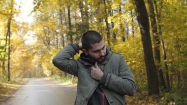 Giysi hood. Yakışıklı delikanlı bir sonbahar ormanda yürüyüş bir ceket giymiş. Parkta niteliğine portre. Ormanda yolda hareket
