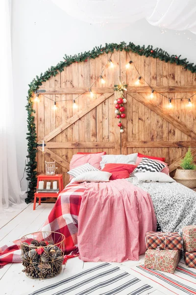 Navidad en el dormitorio de la mañana. Cama doble en Navidad Interior sobre fondo de pared de madera — Foto de Stock