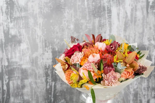 Hermoso ramo de flores mezcladas en un jarrón en la mesa de madera. el trabajo de la floristería en una florería. espacio de copia — Foto de Stock