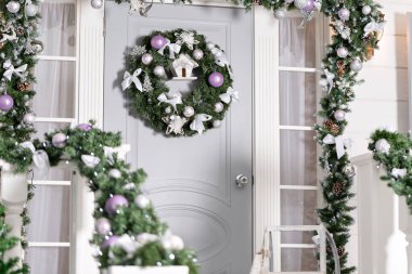 Evin giriş tatil için dekore edilmiştir. Noel dekorasyonu. Garland köknar ağaç dalları ve korkuluk ışıkları