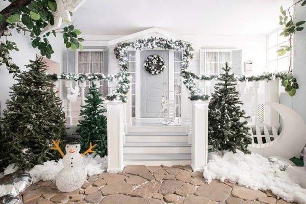 Ház bejáratának díszített ünnepekre. Karácsonyi dekoráció. Garland fenyő fa ágai és a fények a korlát — Stock Fotó