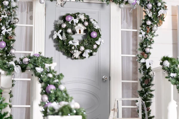 Evin giriş tatil için dekore edilmiştir. Noel dekorasyonu. Garland köknar ağaç dalları ve korkuluk ışıkları