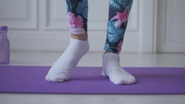 Γυμναστικής στο σπίτι. Νεαρή γυναίκα προθέρμανση πριν την προπόνηση που κάνει ασκήσεις για να τεντώσει την μυς και τις αρθρώσεις — Αρχείο Βίντεο