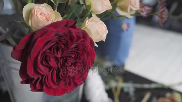 Cierra rosas rojas florecientes. Flores en floristería, taller. Concepto de floristería, artesanía y arte — Vídeo de stock