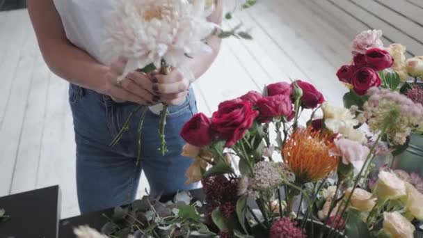 Clase magistral de florista femenina en el trabajo con ramo de flores. Chica haciendo ramo de varias flores de otoño. Mujer de negocios floristería en floristería — Vídeo de stock