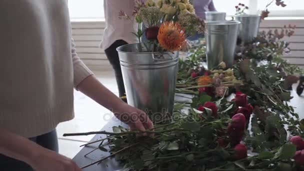 Mästarklass av kvinnliga florist på jobbet med massa blommor. Tjej att göra olika hösten blombukett. Business kvinna florist på blomsteraffär — Stockvideo