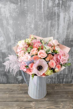 Vazoda karışık çiçeklerden oluşan güzel bir buket. Çiçekçi dükkanındaki çiçekçinin işi. Boşluğu kopyala