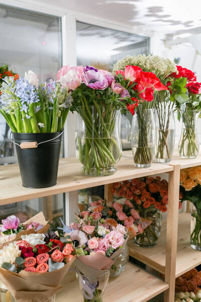 различные сорта. Весенние свежие цветы в холодильнике для цветов в цветочном магазине. Букеты на полке, флористический бизнес
.