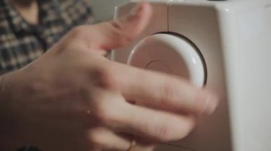 İyi görünümlü genç bir terzi çalışan ve bir dikiş makinesi bir tekstil Studio'yu kullanarak adam. papyon yapar