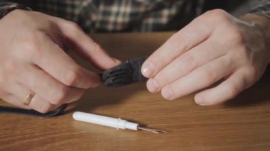 Yakın çekim yünden bir kelebek kravat şeklini oluşturur. Bir terzi çalışan ve bir dikiş makinesi bir tekstil Studio'yu kullanarak iyi görünümlü genç adam.