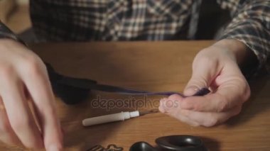 Yakın çekim yünden bir kelebek kravat şeklini oluşturur. Bir terzi çalışan ve bir dikiş makinesi bir tekstil Studio'yu kullanarak iyi görünümlü genç adam.