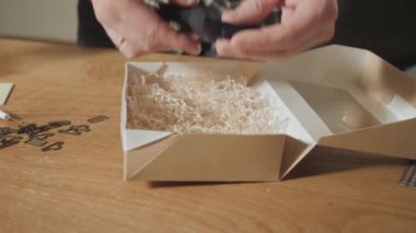 sicim yay bağlama yakın çekim. bitmiş ürünler kelebek kravat ambalaj yünden yapılmış. Bir terzi çalışan ve bir dikiş makinesi bir tekstil Studio'yu kullanarak iyi görünümlü genç adam.