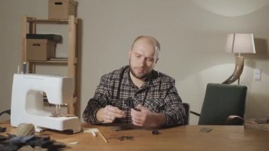 İyi görünümlü genç bir terzi çalışan ve bir dikiş makinesi bir tekstil Studio'yu kullanarak adam. papyon yapar