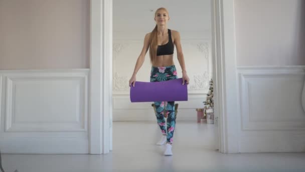 Hem fitness. Ung kvinna kastar sport matta och utbildning gör. — Stockvideo