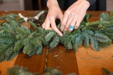 İş yerinde çiçekçi: kadın el Noel süslemeleri çelenk köknar yapım. Mutlu yeni yıl akşam yemeği bayram