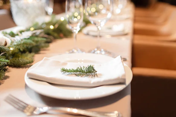 Christmas dinner feast. A decorated dining table with champagne glasses and christmas tree in background — Stock Photo, Image