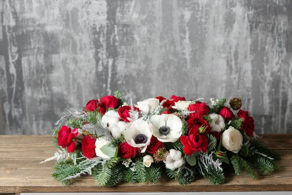 Winter decor. The composition of the branches Nobilis and fresh flowers. Work florist in shop. For decorating a family dinner — Stock Photo, Image