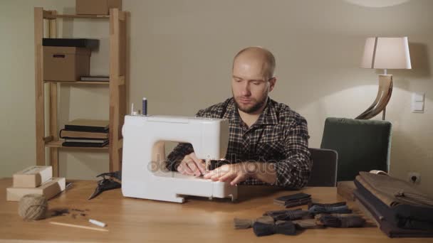 Hace pajaritas. Joven trabajando como sastre y utilizando una máquina de coser en un estudio textil . — Vídeo de stock