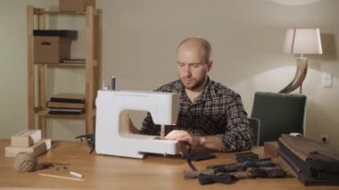 İyi görünümlü genç bir terzi çalışan ve bir dikiş makinesi bir tekstil Studio'yu kullanarak adam. papyon yapar