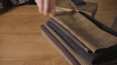 portre. Yün yığından seçer. Bir terzi çalışma ve atölyede bir dikiş makinesi kullanarak genç adam.