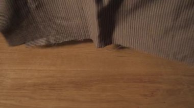 Terzi yün kesim masası üzerinde ortaya konuyor. Bir terzi çalışma ve atölyede bir dikiş makinesi kullanarak genç adam.