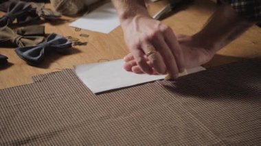 Kesme yün kumaş. çizgi deseni. Yünlü kumaş papyon. Bir terzi çalışan ve bir dikiş makinesi bir tekstil Studio'yu kullanarak genç adam.