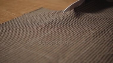 Closeup kesme kahverengi ekose yün kumaş. çizgi deseni. Bir terzi çalışma ve atölyede bir dikiş makinesi kullanarak genç adam.