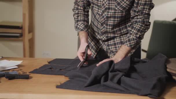 Řezací tmavé Vlněné tkaniny. vzorek čáry. Mladý muž, pracující jako Krejčí a používání šicího stroje v dílně. — Stock video